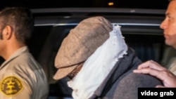 Марк Бассели Юсуфті тергеуге әкетіп барады. Лос-Анджелес, 15 қыркүйек 2012 жыл. (Көрнекі сурет).
