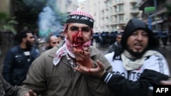 Egyptian supporters of President Muhammad Morsi help a wounded comrade during clashes with Morsi's opponents in the Mediterranean coastal city of Alexandria on December 21.