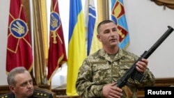 Украинский офицер демонстрирует журналистам оружие, захваченное, по его словам, у российских солдат (18 мая 2015 г.) 