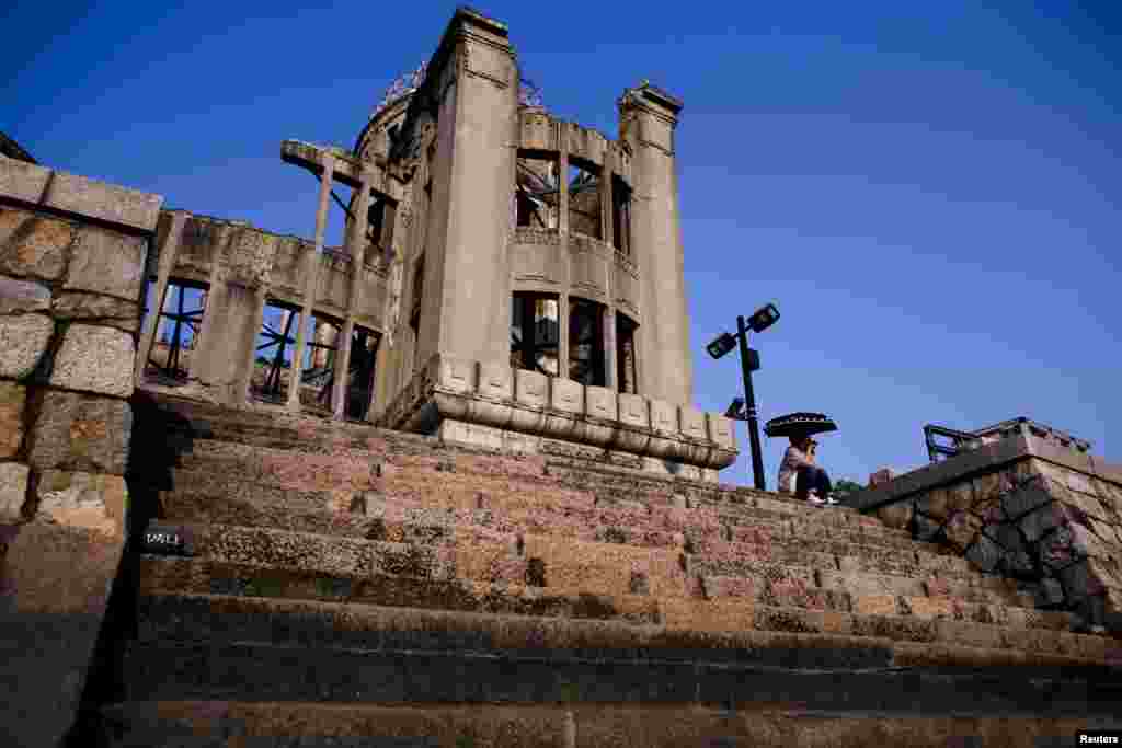 A woman sits in front of the Atomic Bomb Dome in Hiroshima, western Japan. On August 6, Japan marks the 70th anniversary of a nuclear attack on Hiroshima, where the United States dropped an atomic bomb in 1945, killing about 140,000. (Reuters/​Thomas Peter)