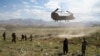 FILE: A U.S. military Chinook helicopter lands on a field outside the governor's palace in Wardak Province in June 2019.