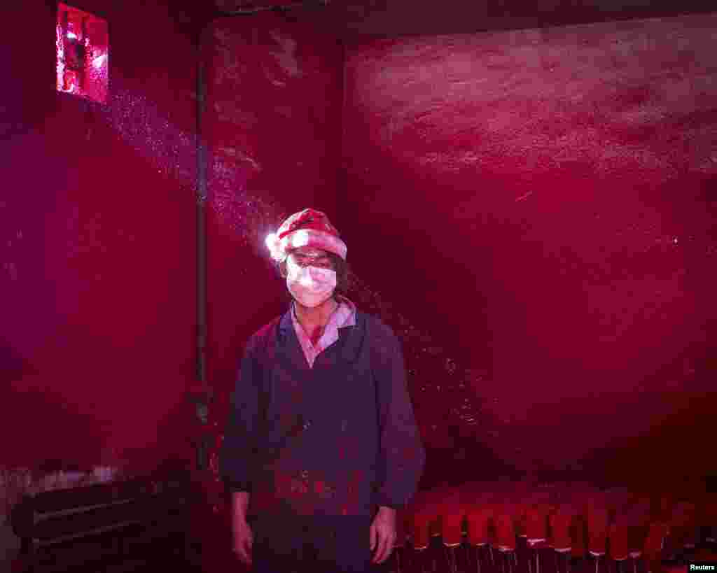 Ronghui Chen, Chinese photographer of City Express, won Second Prize in the Contemporary Issues Category, Singles,&nbsp;​with this picture of Wei, a 19-year-old Chinese worker, wearing a face mask and a Santa hat, standing next to Christmas decorations being dried in a factory as red powder used for coloring hovers in the air, in Yiwu, China.