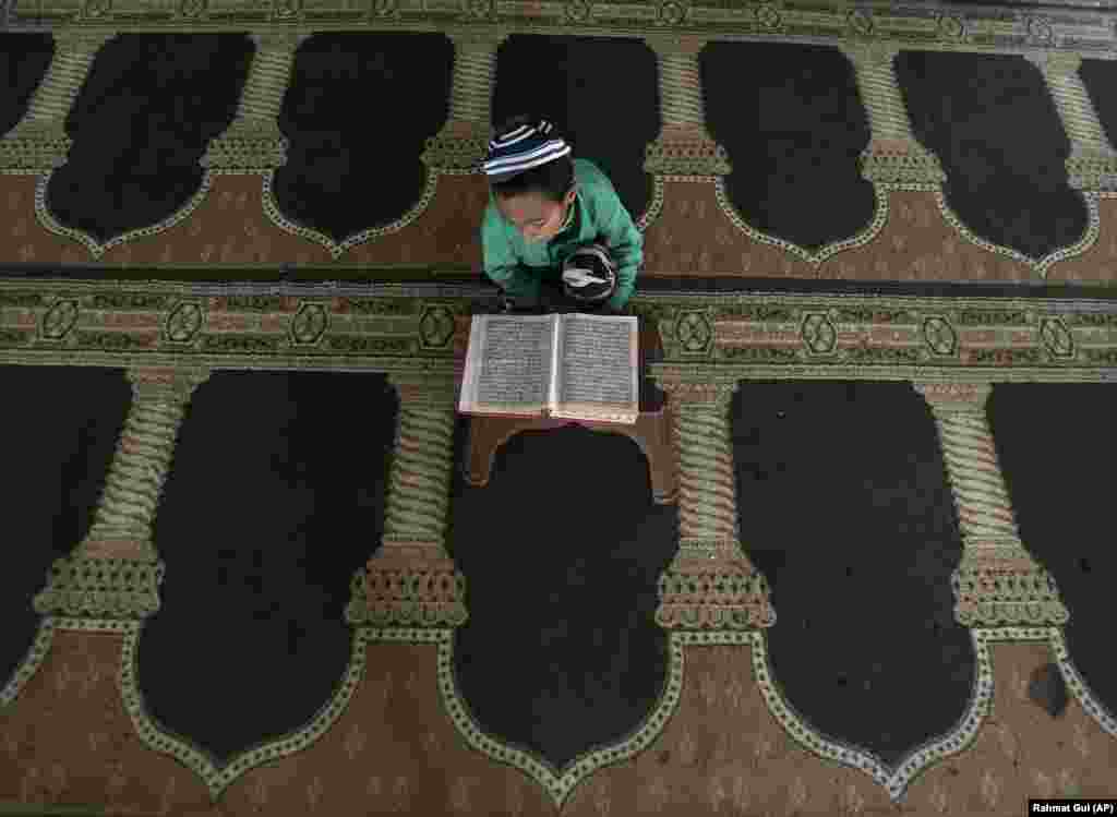 An Afghan boy reads from the Koran during the Muslim holy month of Ramadan at a mosque in Kabul. (AP/Rahmat Gul)