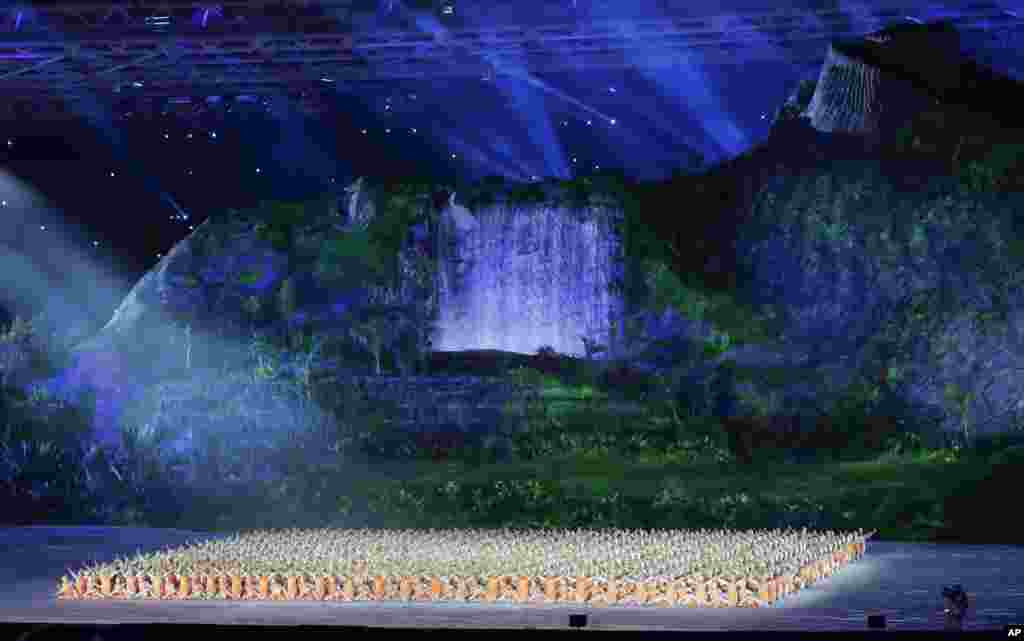 На церемонии открытия. Декорации на основной сцене стадиона, где проходило открытие игр, напоминали гигантский водопад и джунгли.