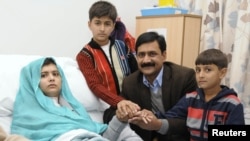 Malala Yousafzai is seen with her father Ziauddin and her two younger brothers, Khushal Khan and Atal Khan (right), as she recuperates at the Queen Elizabeth Hospital in Birmingham on October 26.