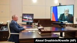 Russian President Vladimir Putin listens to Prime Minister Mikhail Mishustin during a teleconference at the Novo-Ogaryovo residence outside Moscow on April 30. Mishustin announced in the video call that he would self-isolate because he had tested positive for the coronavirus.