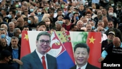 Government supporters hold a banner of Serbian President Aleksandar Vucic (left) and Chinese President Xi Jinping at a demonstration outside parliament in Belgrade in May 2020.