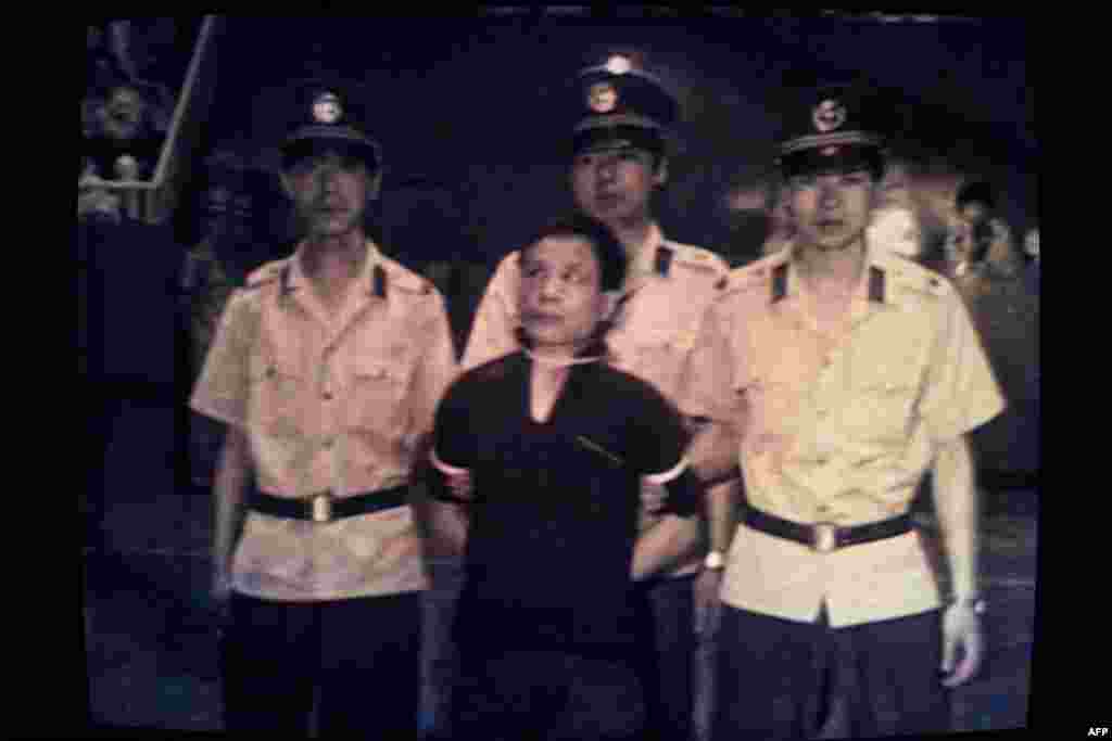 A screen shot from Japanese TV shows an accused "rioter" being led into a courtroom on June 22 for a summary trial before his execution. Hundreds of people were imprisoned for their roles in the protests.