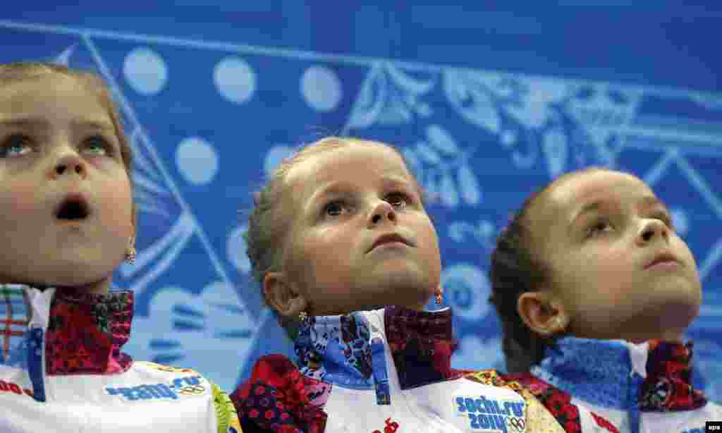 Flower girls look on ahead of the men&#39;s figure skating short program at the Iceberg Palace.