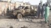 Residents look at an Army vehicle destroyed in fighting between Afghan security forces and Taliban in Farah city on May 16.