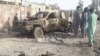 Residents look at an army vehicle that was damaged during fighting between Afghan security forces and Taliban fighters in Farah Province on May 16.