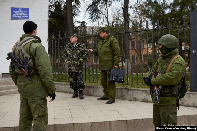Российские военные встречаются с украинским офицером (второй слева) перед украинской военной базой