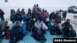 Astronautët amerikanë, Joe Acaba (majtas) dhe Mark Vande Hei (djathtas), dhe ai rus, Aleksandr Misurkin nga Rusia, pak minuta pasi kanë arritur në Kazakistan.