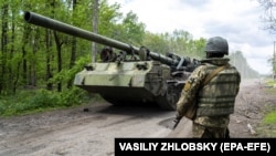 Украина сарбазы өздігінен жүретін ауыр артиллериялық қондырғыға қарап тұр. Харьков облысы, 17 мамыр 2022 жыл.