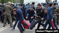 Полицейские задерживают участника протеста в Нур-Султане в день досрочных президентских выборов. 9 июня 2019 года.