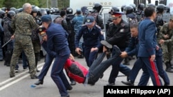 Қазақстанда кезектен тыс президент сайлауы күні наразылық акциясына шыққане азаматтарды полиция көшеден әкетіп барады. Нұр-Сұлтан, 9 маусым 2019 жыл.