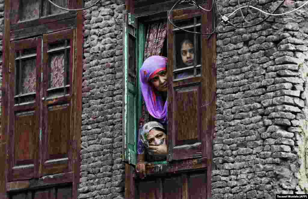 Local residents look out from a window near the site were a gunbattle took place between suspected militants and Indian government forces in downtown Srinagar, Kashmir, on October 17. (AFP/Tauseef Mustafa)
