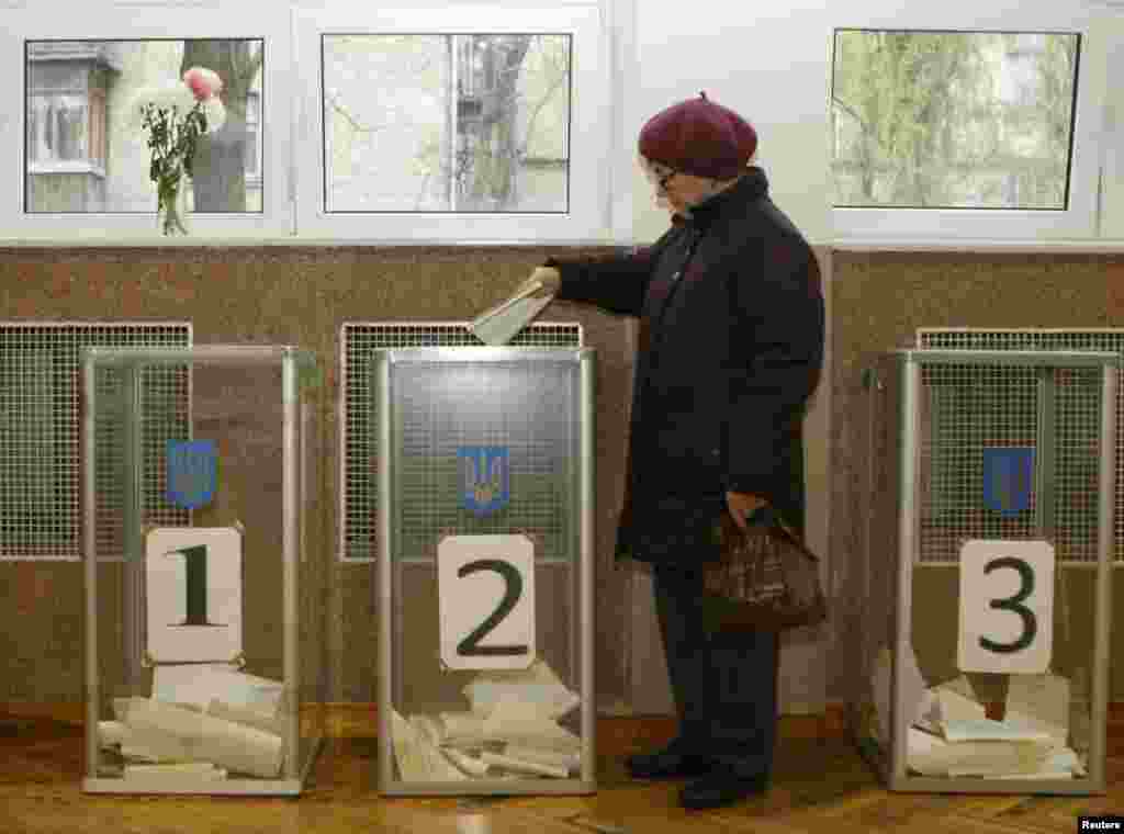 A woman casts her vote at a polling station in Kyiv.