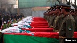 Afghan honor guards stand next to coffins as they pay tribute to soldiers who were killed in an Taliban attack in Ghaziabad district of Konar Province, during a tribute ceremony in Kabul on February 24.