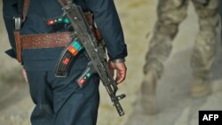 A member of the Afghan National Police walks behind a U.S. Army soldier during a joint patrol in Kandahar Province. So-called "green-on-blue" attacks are often attributed to cultural differences.