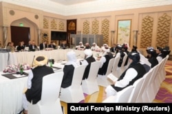 Taliban negotiators and Qatari officials meet in Doha in March 2019.