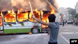 A Green Movement supporter in Tehran, armed with sticks to confront riot police in June 2009.