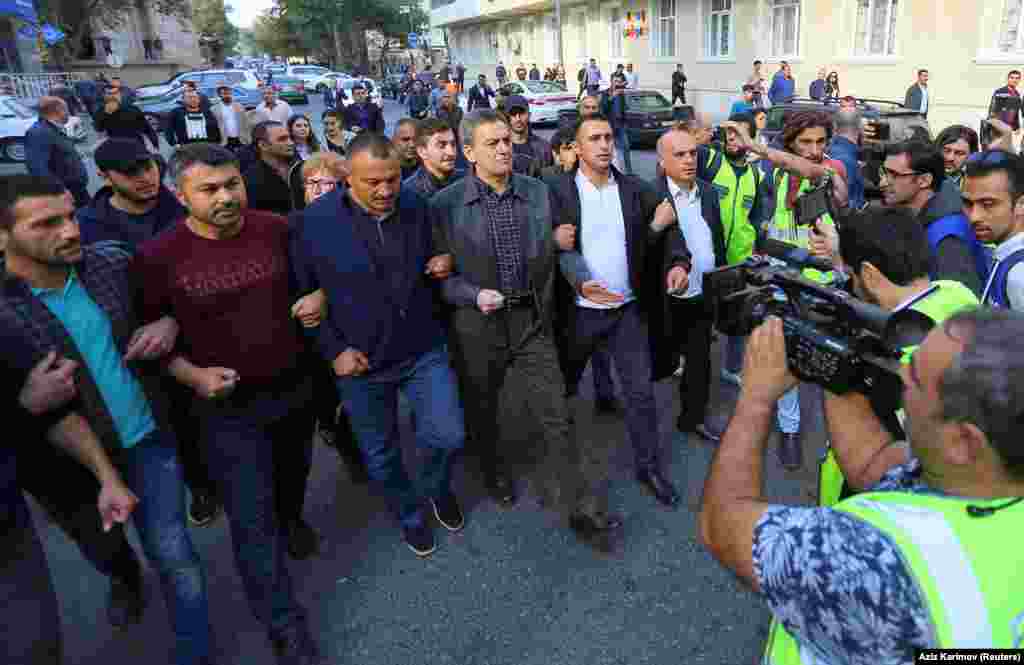 Оппозиционные деятели, в том числе Али Керемли (в центре, в сером пиджаке) на марше в Баку. Керемли задержали и, по его словам, подвергли пыткам.