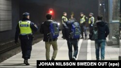 پلیس سوئد چند پناهجوی جوان را در یک ایستگاه قطار در بیرون مالمو همراهی می‌کند