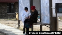 Женщина с ребенком на автобусной остановке на окраине Астаны. 