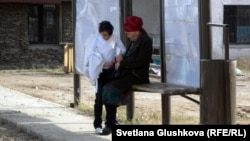 Егде тартқан әйел немересімен автобус аялдамасында отыр. Астана, 16 қазан 2011 жыл. (Көрнекі сурет) 