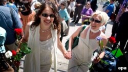 A soon-to-be-married couple works their way through the crowd outside City Hall in San Francisco in June 2008.