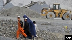 Афганская женщина с детьми идет вдоль карьера. 5 октября 2011 года.