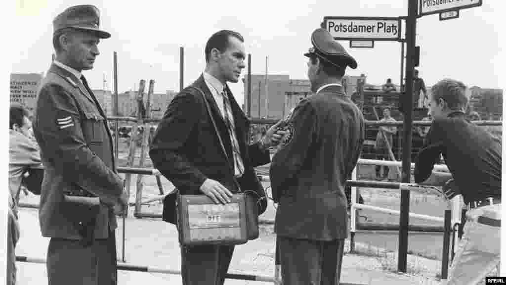 William Marsh, a Szabad Európa Rádió berlini irodájának vezetője készít interjút&nbsp; a Potsdamer Platz egyik rendőrtisztjével. A háttérben kelet-német munkások építik már a végleges falat, amely kettévágta a Potsdamer Platzot, és a teret sivár pusztasággá változtatta.