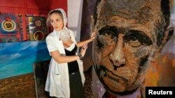 Artista ucraineană Daria Marcenko cu un portret al lui Putin intitulat "Chipul războiului", realizat din cartușe trase pe front.