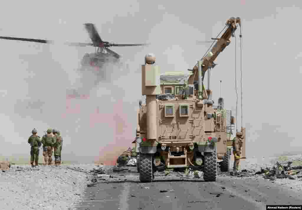 Trupat e SHBA-së duke vlerësuar dëmin ndaj një automjeti të blinduar që i përket koalicionit ushtarak të udhëhequr nga NATO-ja, pas një sulmi vetëvrasës në Kandahar, Afganistan.