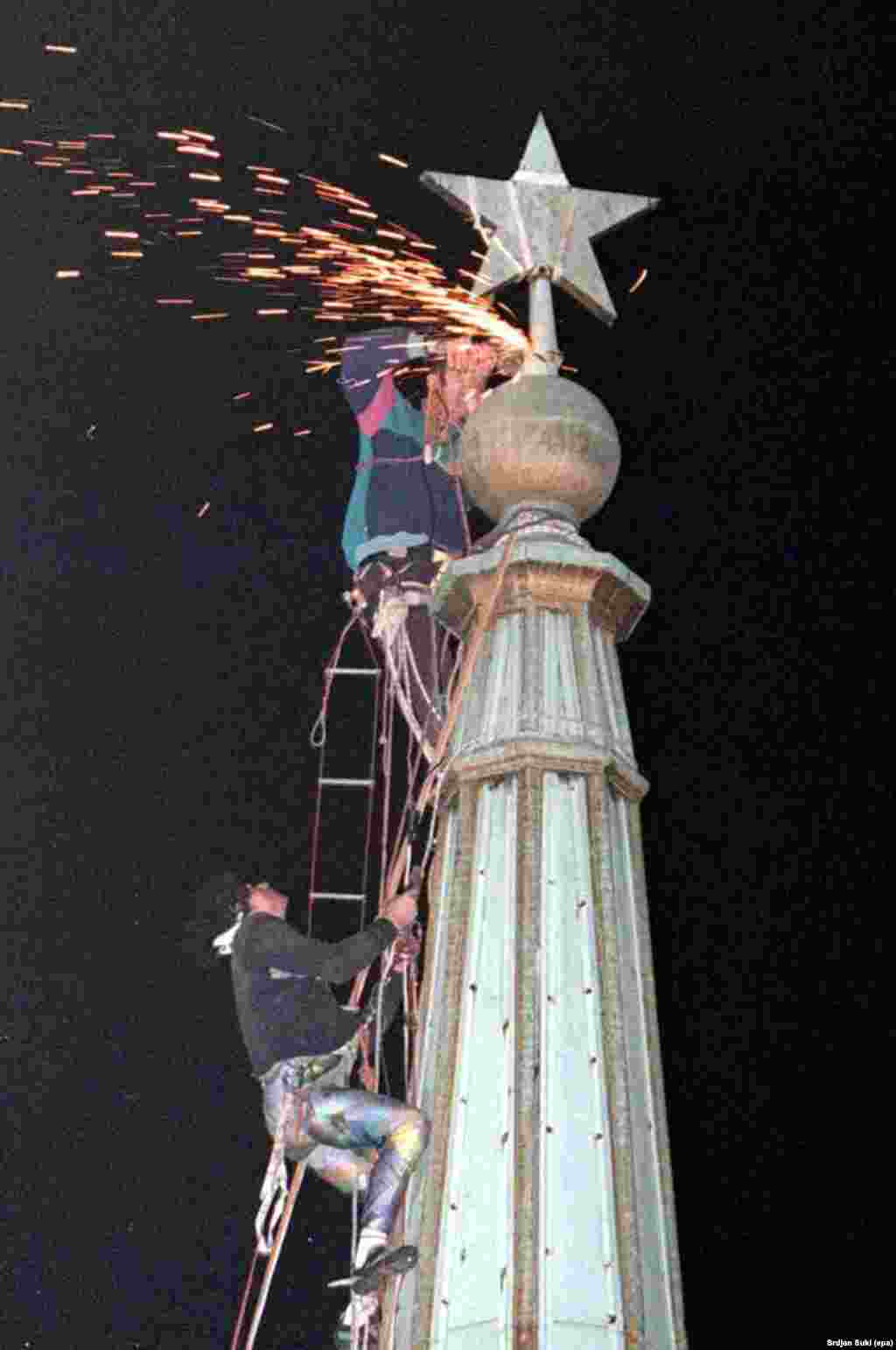 Climbers cut off the communist star from the tower of Belgrade's town hall in 1997 after months of street protests in the Serbian capital. 