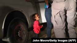 Dvogodišnja djevojčica plače dok njenu majku ispituje policija na meksičko-američkoj granici, juni 2018.