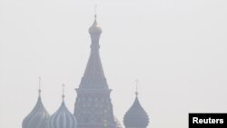 People walk along Red Square, with St. Basil's Cathedral seen through heavy smog caused by peat fires in out-of-city forests, in Moscow on July 26.