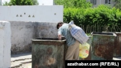 Türkmenisztán ‒ egy hajléktalan férfi guberál egy szemetes konténerből