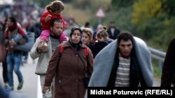 Беженцы и мигранты с детьми направляются к венгерской границе. Хорватский город Ботово, 16 октября 2015 года.