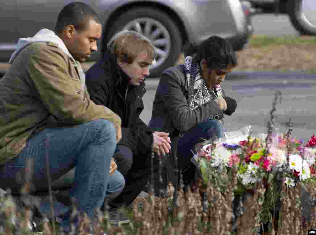 Жители города Ньютаун несут цветы к месту трагедии