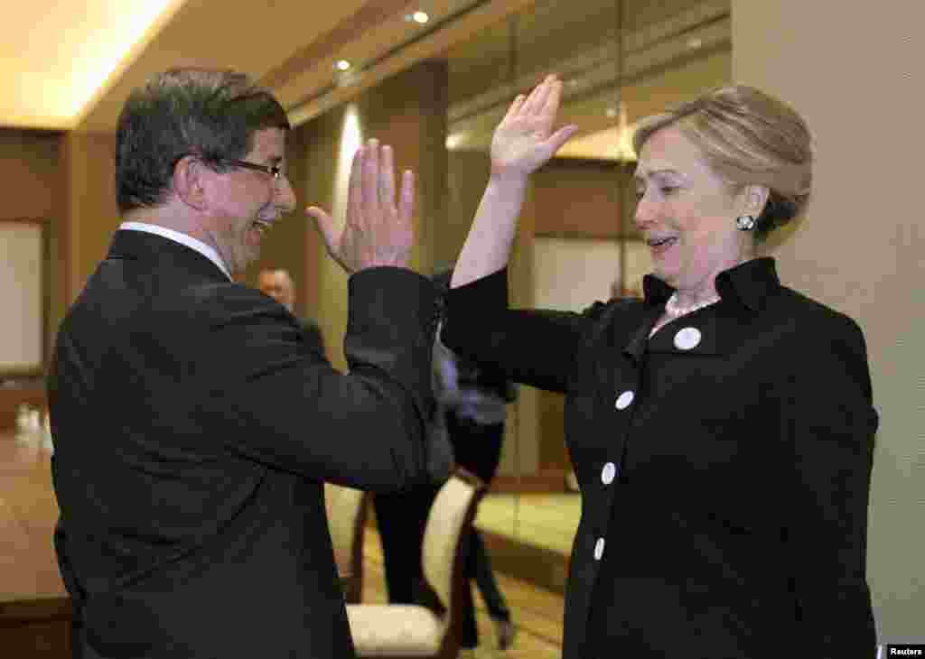 Hillary Clinton gives Turkish Foreign Minister Ahmet Davutoglu (left) a &quot;high five&quot; at the start of their bilateral meeting at the Emirates Palace Hotel in Abu Dhabi in the United Arab Emirates on June 9, 2011.