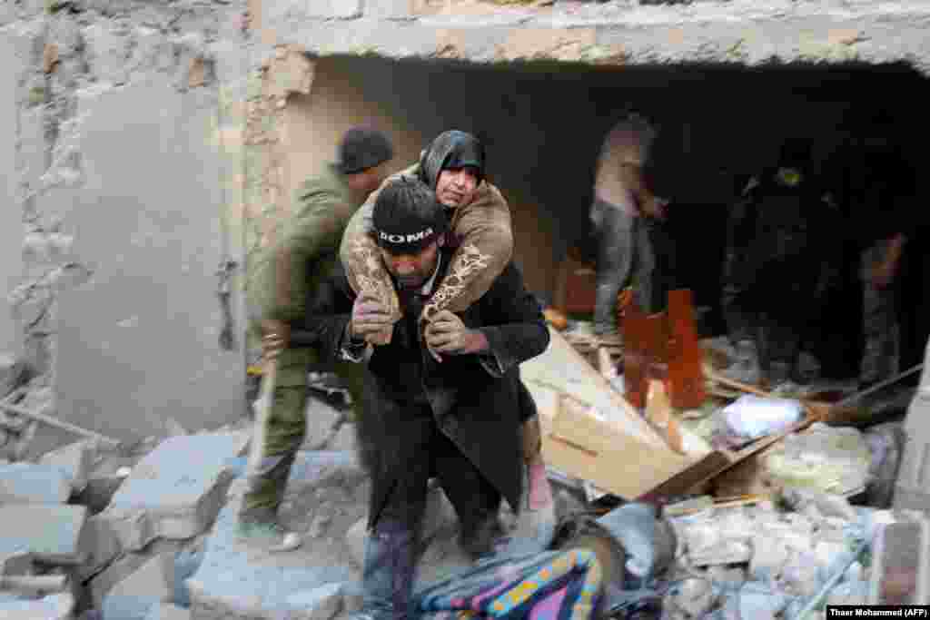 A Syrian rescuer carries a woman from the rubble of a building following reported air strikes on Aleppo's rebel-held district of Al-Hamra. (AFP/Thaer Mohammed)