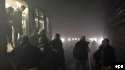 После взрыва люди покидают поезд в туннеле метро