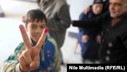 A young Egyptian gives the "victory" sign during voting in Cairo on January 14.