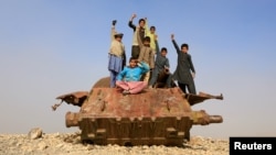 Afghan children play on the remains of a Soviet-era tank on the outskirts of Jalalabad.