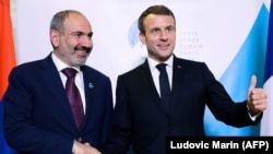 FRANCE -- French President Emmanuel Macron (R) shakes hands with Armenian Prime Minister Nikol Pashinian during a bilateral meeting as part of the Paris Peace Forum, in Paris, November 12, 2019