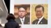 Прохожая в Токио возле телевизионного экрана, где демонстрируется клип с фотографиями лидера Северной Кореи Ким Чен Ына и президента Южной Кореи Мун Чжэ Ина