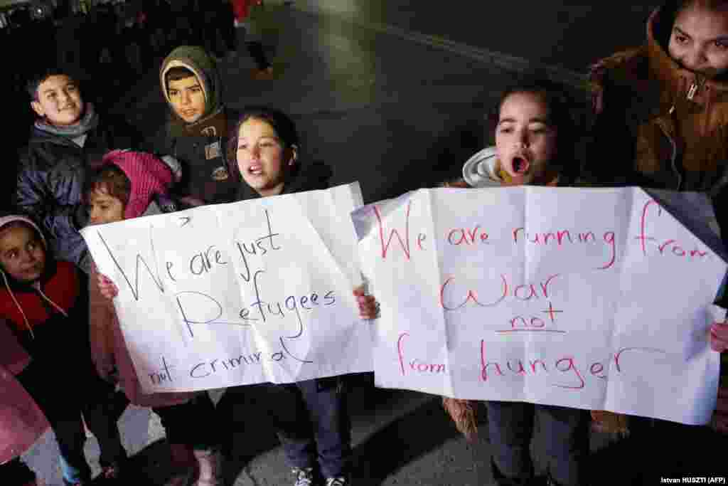 Migrant children demonstrate with placards near the border fence at Kelebija on February 6.