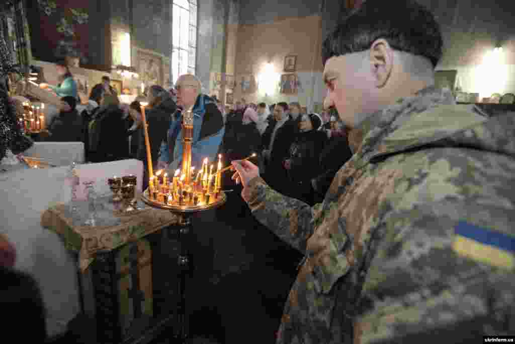 Військовослужбовець ставить свічку під час Різдвяного богослужіння в соборі святого Івана Богослова, Харків, 7 січня 2016 року.